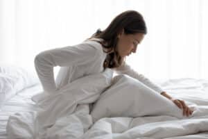 Woman recovering in bed from lumbar spine surgery in Sugar Land, TX
