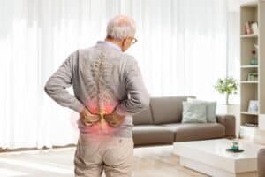 Elderly Sugar Land resident dealing with back pain caused by a vertebral fracture